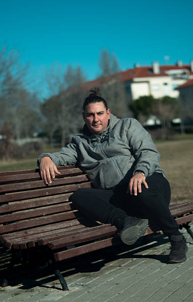 istock Young man relaxing on park bench enjoying solitude 2255507020