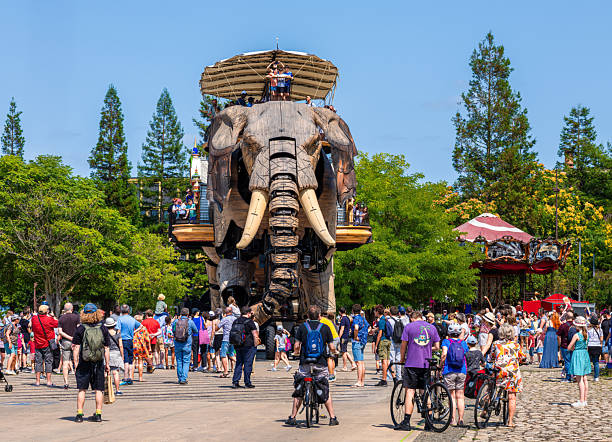 Nantes, France - August 5, 2025: A large mechanical elephant sprays water at visitors in the industrial-style gallery La Galerie des Machines in Nantes, Brittany.
