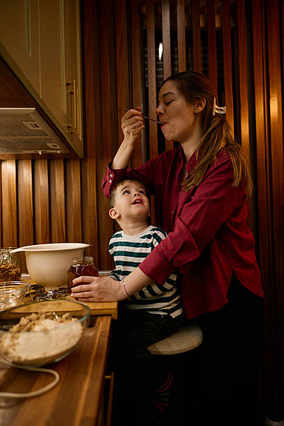 Mother and son enjoy baking together in a cozy kitchen, sharing a sweet moment