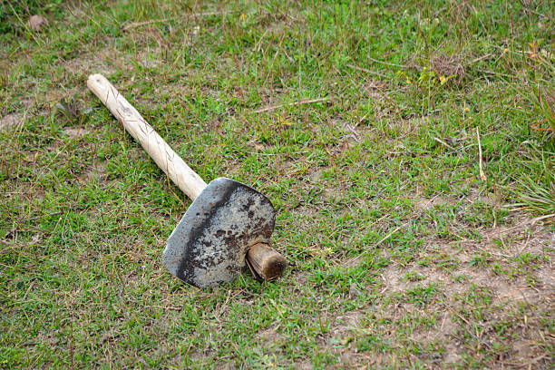 Iron hoe tool on green grass field
