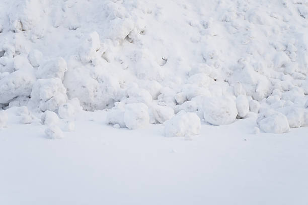 Snowdrift with packed snow clumps and irregular icy formations creating natural winter surface texture and minimal outdoor ground background