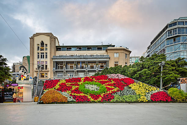 Santa Cruz, Tenerife, Spain, Europe - December 18th 2025: A large flowerbed arranged with plants in different colors forms decorative figures created for the Christmas season. Behind the installation stands a classical Spanish building, providing an architectural backdrop to the festive display.
