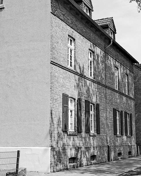 istock Brick building with shadowed windows and shutters on a sunny day in an urban setting 2255521360