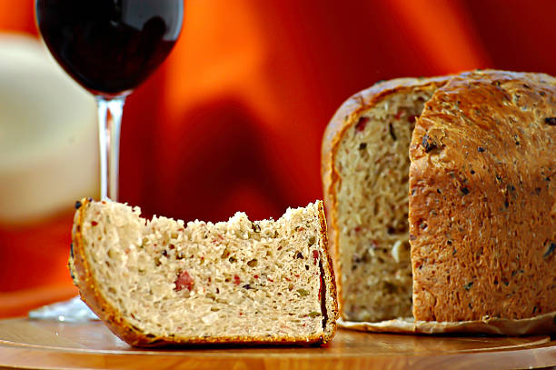 close up, candied panettone slice, cut panettone, on a wooden board, wine glass, blurred background, pumpkin color