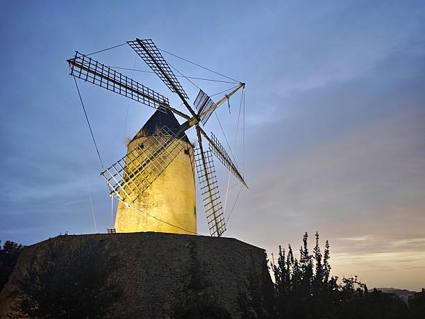 A traditional moli (windmill) in Santa Ponsa, Mallorca, photographed at sunset with warm Mediterranean light and a dramatic evening sky.