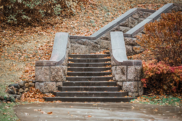 Autumn scene of stone stairs on a hill at a public park with fallen leaves.