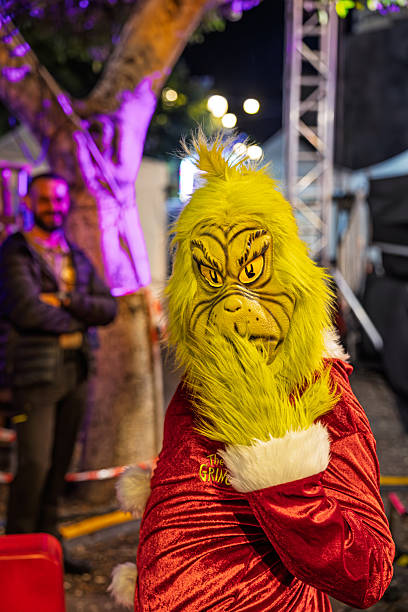Santa Cruz, Tenerife, Spain, Europe - December 21th 2025: A man dressed as a demon stands at a marketplace event, serving as a light‑hearted guard to keep people away from a backstage area. The scene documents the use of costumed staff during the event, showing how organizers manage access while maintaining a humorous and festive atmosphere.