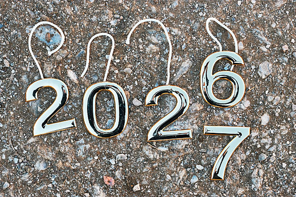 istock Shiny Chrome Year Numbers 2027 On Rough Asphalt Surface For New Year Concept 2255542261