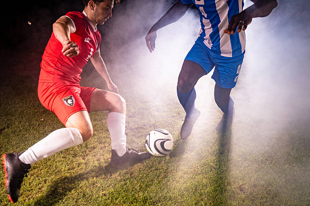 istock Soccer Players in Red and Blue Competing on a Grassy Field 2255542629