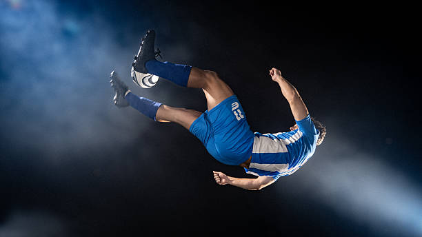 A man is jumping in the air with his arms outstretched. The sky is blue and there are clouds in the background. Scene is joyful and energetic