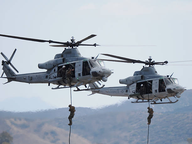 San Diego, California, USA - September 28, 2025: US Marines descend simultaneously via fast ropes from two hovering UH-1Y Venom helicopters during a coordinated tactical insertion demonstration.