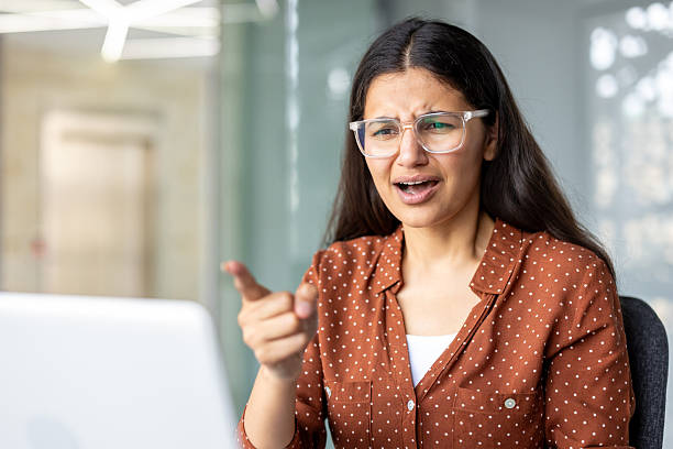 istock Angry woman arguing during video call pointing at laptop 2255543364