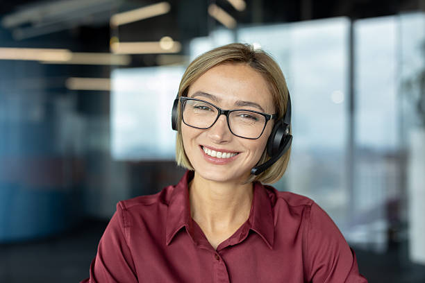 istock Smiling customer service representative wearing headset and glasses in office 2255545251