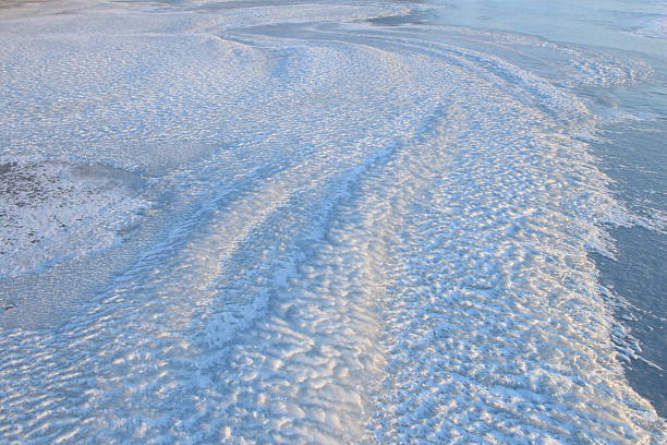 Close-up of snow texture on a ski slope with skis imprints.