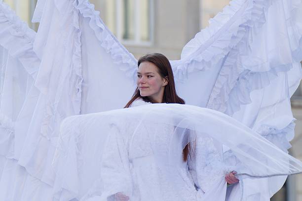 Woman dressed as an angel with large white wings during the Three Kings Parade in Warsaw.