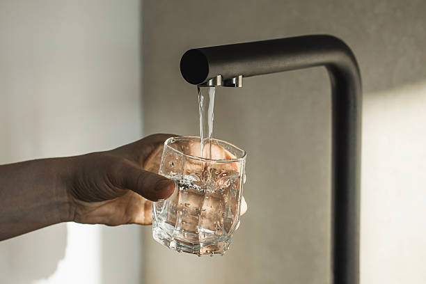 close-up view of water flowing from tap into glass