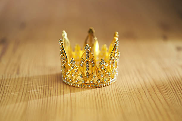 golden crown with diamond on wood table