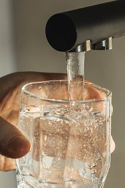 istock Drinking water. Fill glass with water from tap 2255567617
