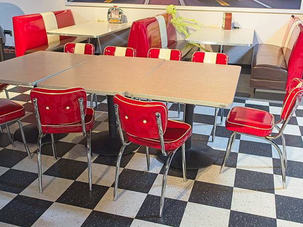 Old time 1950s diner with checkerboard floor and red upholstered chairs.