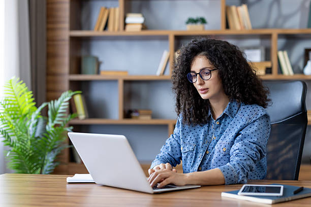 istock Young woman working remotely at home office using laptop 2255573554