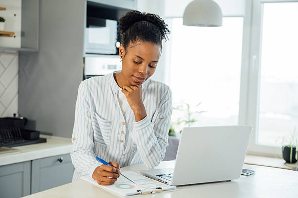 istock Latina entrepreneur working remotely from home on laptop in modern apartment 2255579771