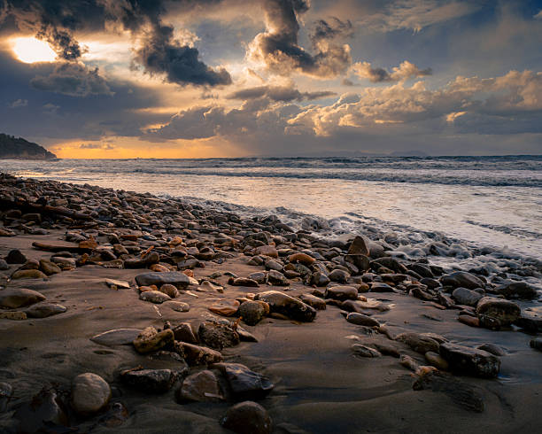 Waves crashing on the rocks during a beautiful sunset over the Pacific Ocean in General Villamil Playas, Guayas, Ecuador, creating a dramatic and colorful scene