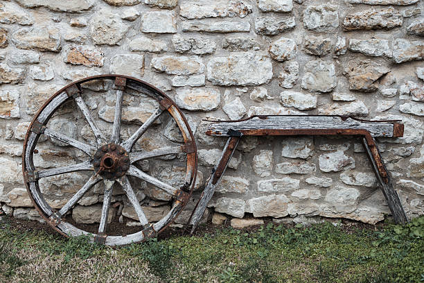 Wooden farming tools and wagon wheel hung on the cottage wall, traditional element of rural heritage.