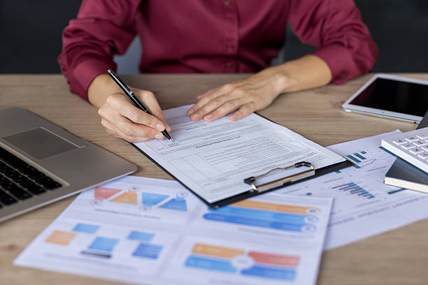 istock Businesswoman signing document at office desk with papers 2255583620