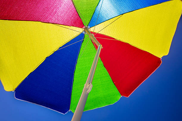 Multicolored beach umbrella against the sun on the background of the beach
