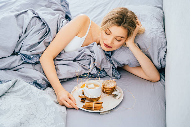 istock Blond white woman enjoying slow breakfast in bed with coffee 2255590209