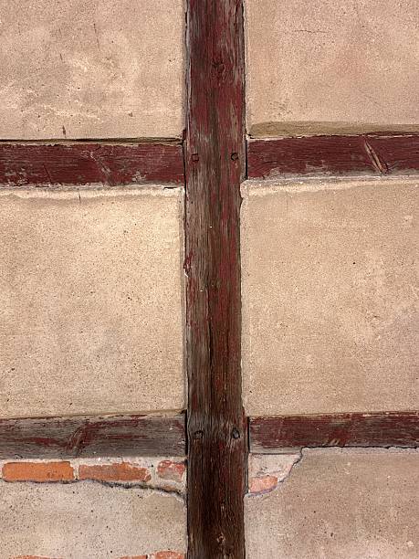 Traditional German half-timbered house wall with exposed wooden beams forming a cross structure between plastered sections.