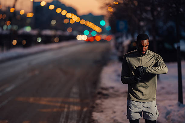 Male athlete checking smartwatch after winter running workout