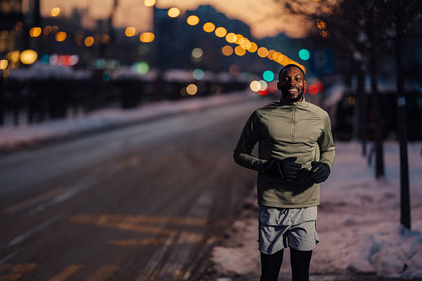 Man running in city at night during winter