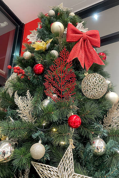 istock New Year shiny decor hang on green Christmas tree, silver and red balls and bows 2255598077