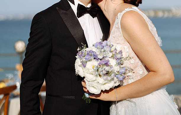 Happy bride and groom on their wedding hugging. Closeup Bride holding a bouquet