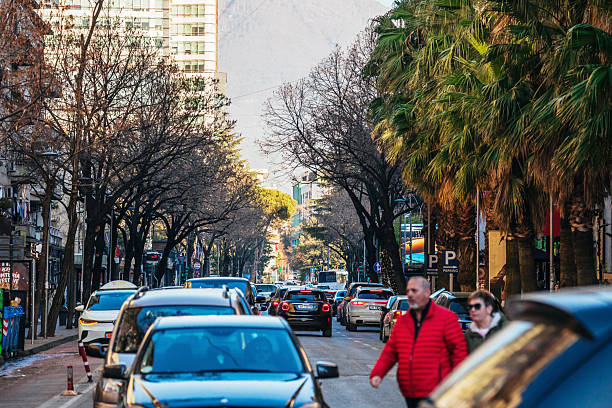 Tirana, Albania - Everyday traffic with cars, bikes and people in city centre.