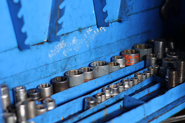 ​A collection of various sized metal socket wrench heads organized in a blue industrial toolbox, essential hand tools for automotive repair, mechanical maintenance, and workshop engineering.