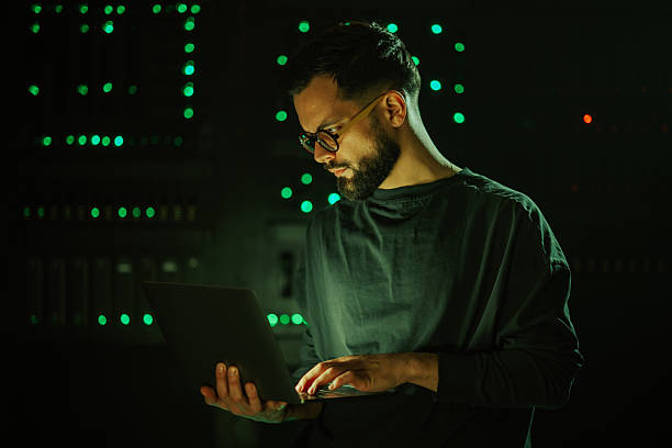 istock Cybersecurity specialist working on laptop in dark data center 2255604772