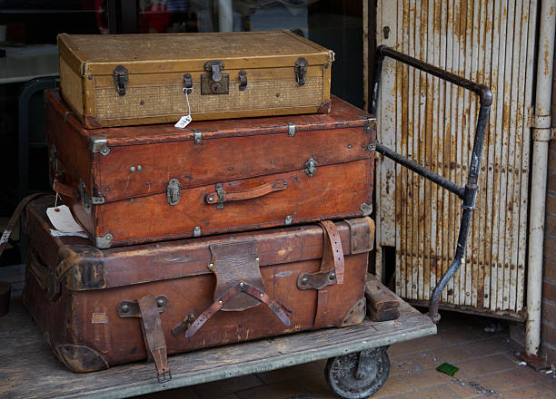Old suitcases stacked on a hardwood floor, conveying antique and retro travel