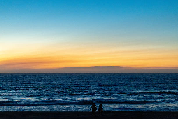 Silhouetted people on beach during sunset in Siesta Key, Sarasota, Florida