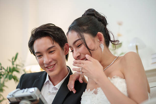 istock Asian wedding couple smiling while reviewing camera photos 2255624917