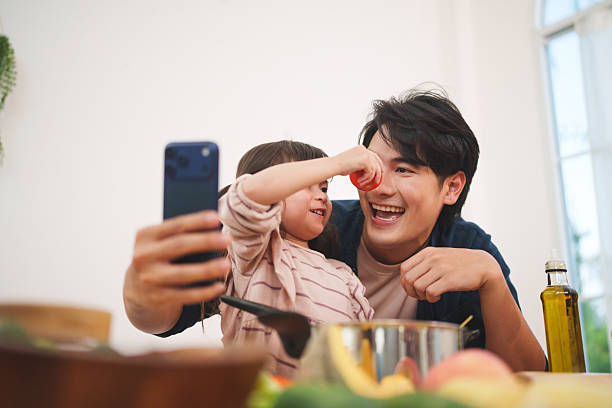 istock Asian father and daughter taking selfie while cooking at home 2255624931