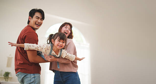 istock Asian parents playing with daughter at home 2255624938