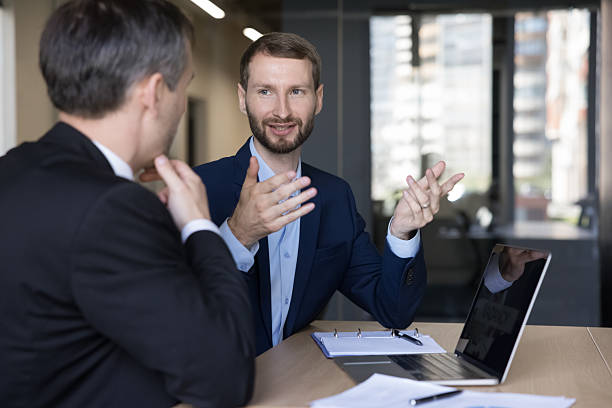 istock Two office man colleagues discuss business project use laptop 2255631557