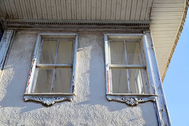 Weathered window frame with peeling paint, revealing layers of history and texture. Perfect for themes of decay, vintage charm or forgotten places