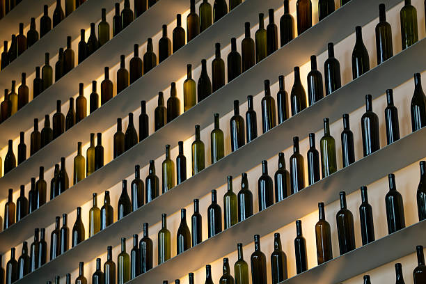 This striking image showcases a wall in a wine bar adorned with illuminated bottles, creating a warm and inviting atmosphere. The soft glow from the bottles highlights the rich colors of the wines, enhancing the overall aesthetic of the space. This scene captures the essence of a cozy gathering spot, perfect for wine lovers and social events. Ideal for projects related to hospitality, gastronomy, or nightlife, this image invites viewers to experience the charm and sophistication of wine culture, encouraging exploration and enjoyment of fine wines in a welcoming environment.