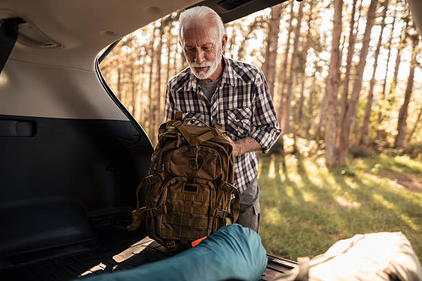 istock Senior man packing backpack into car trunk for hike 2255642282