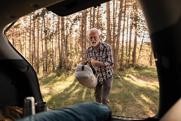 istock Senior man unpacking camping gear from car trunk 2255642474