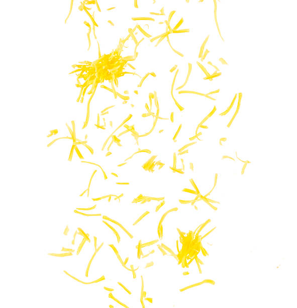 Grated yellow cheese shavings scattered on white background, falling dairy ingredient concept
