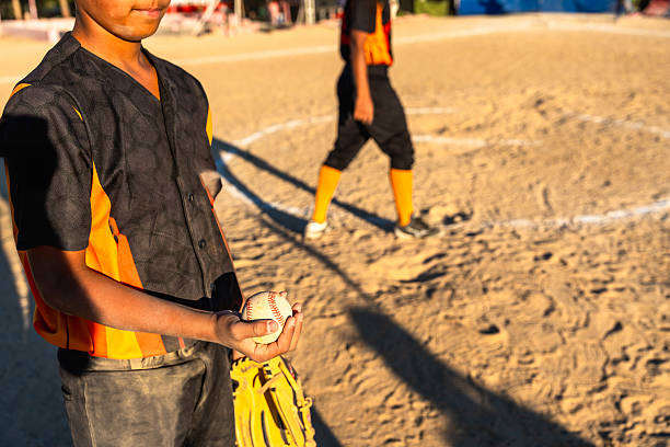 A Kid play football on outdoor field at the end of the day